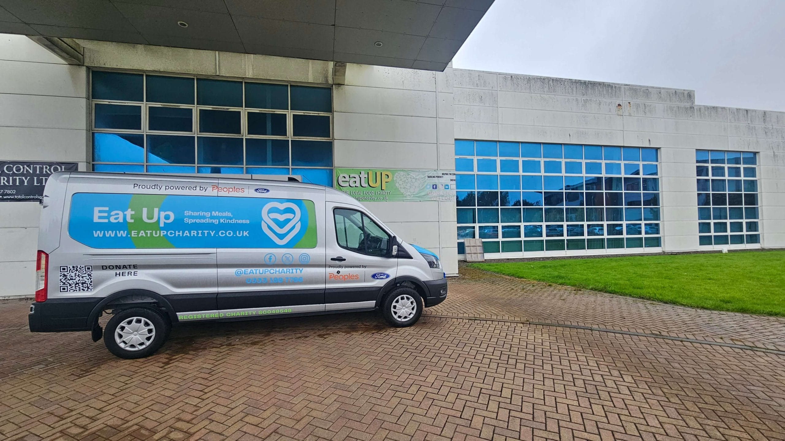 Electric mini van outside Eat up office building