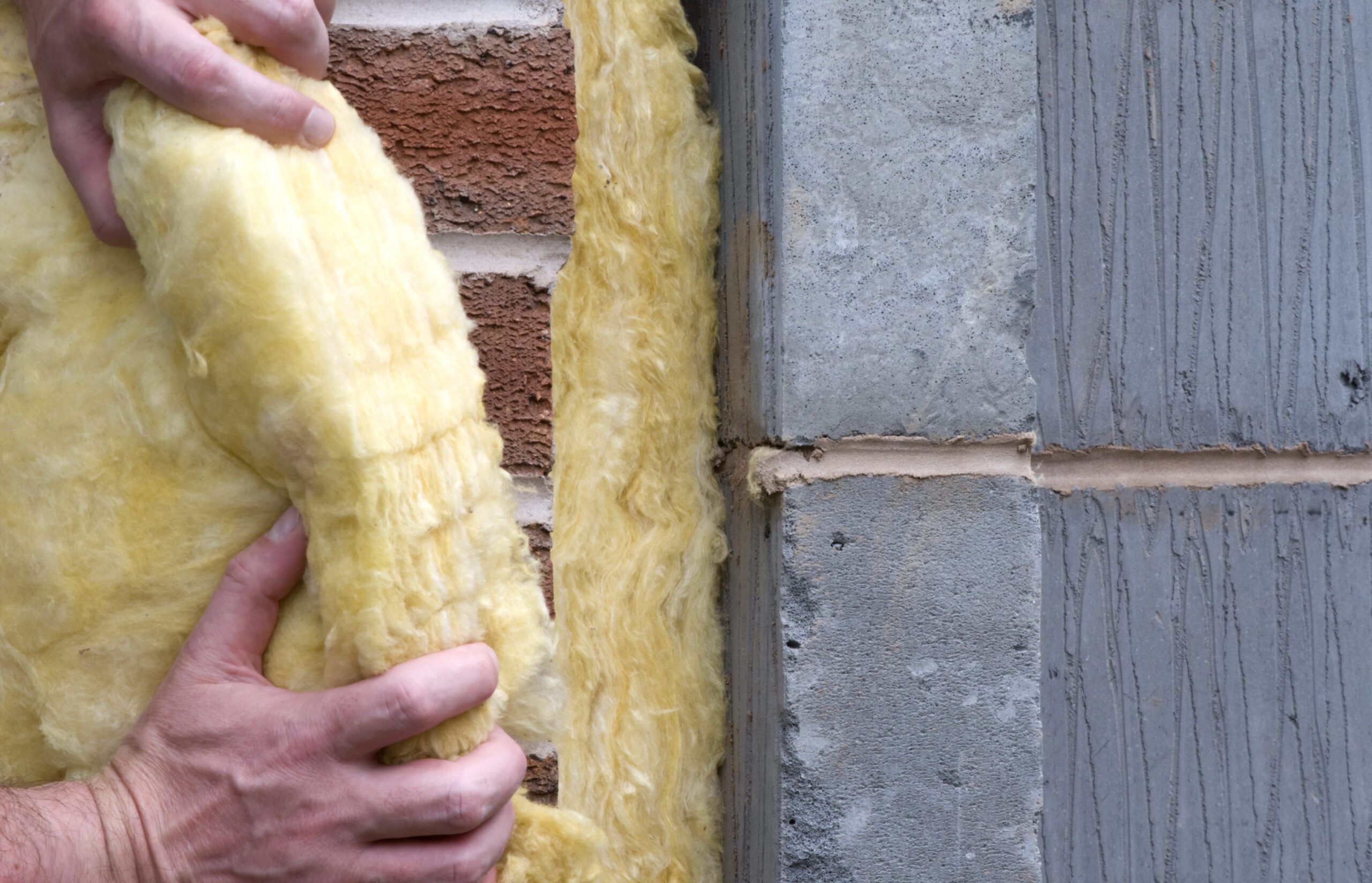 A close up of someone installing foam insulation to an external wall.