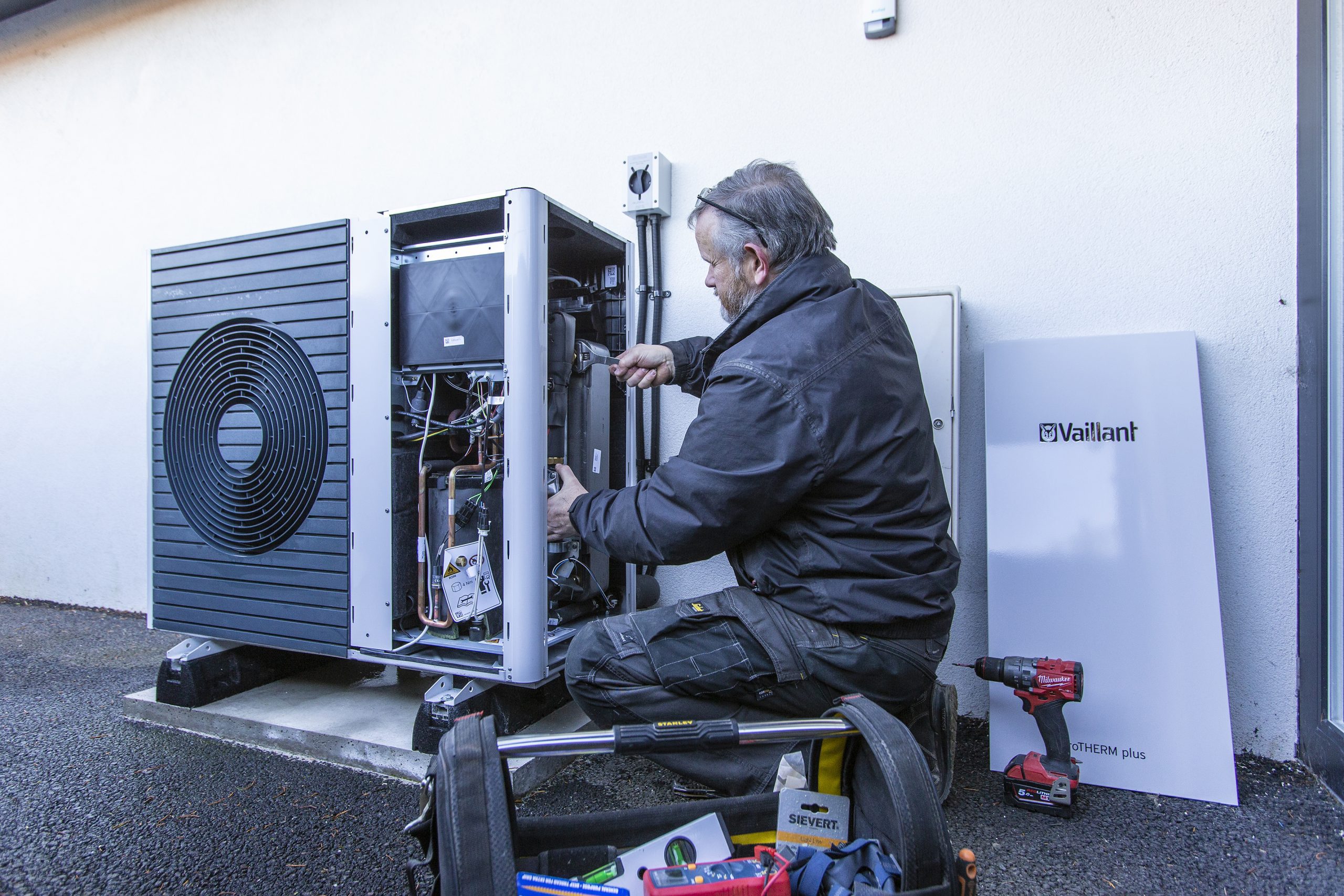Installer installing a heat pump