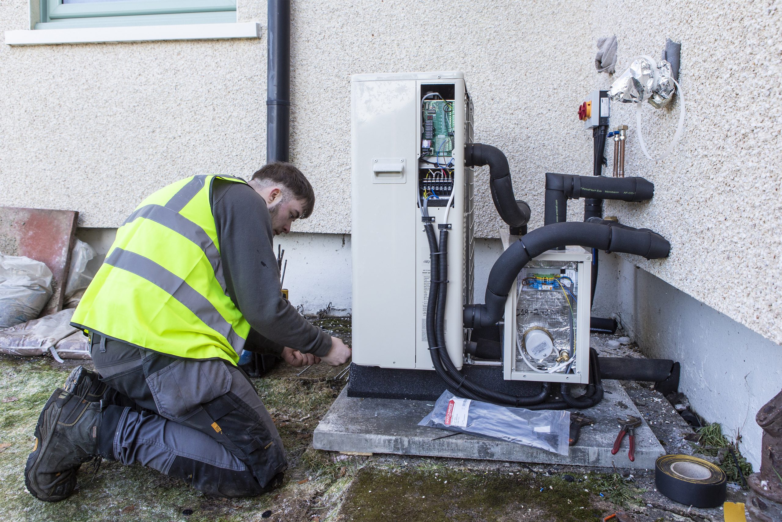 installer works on a heat pump