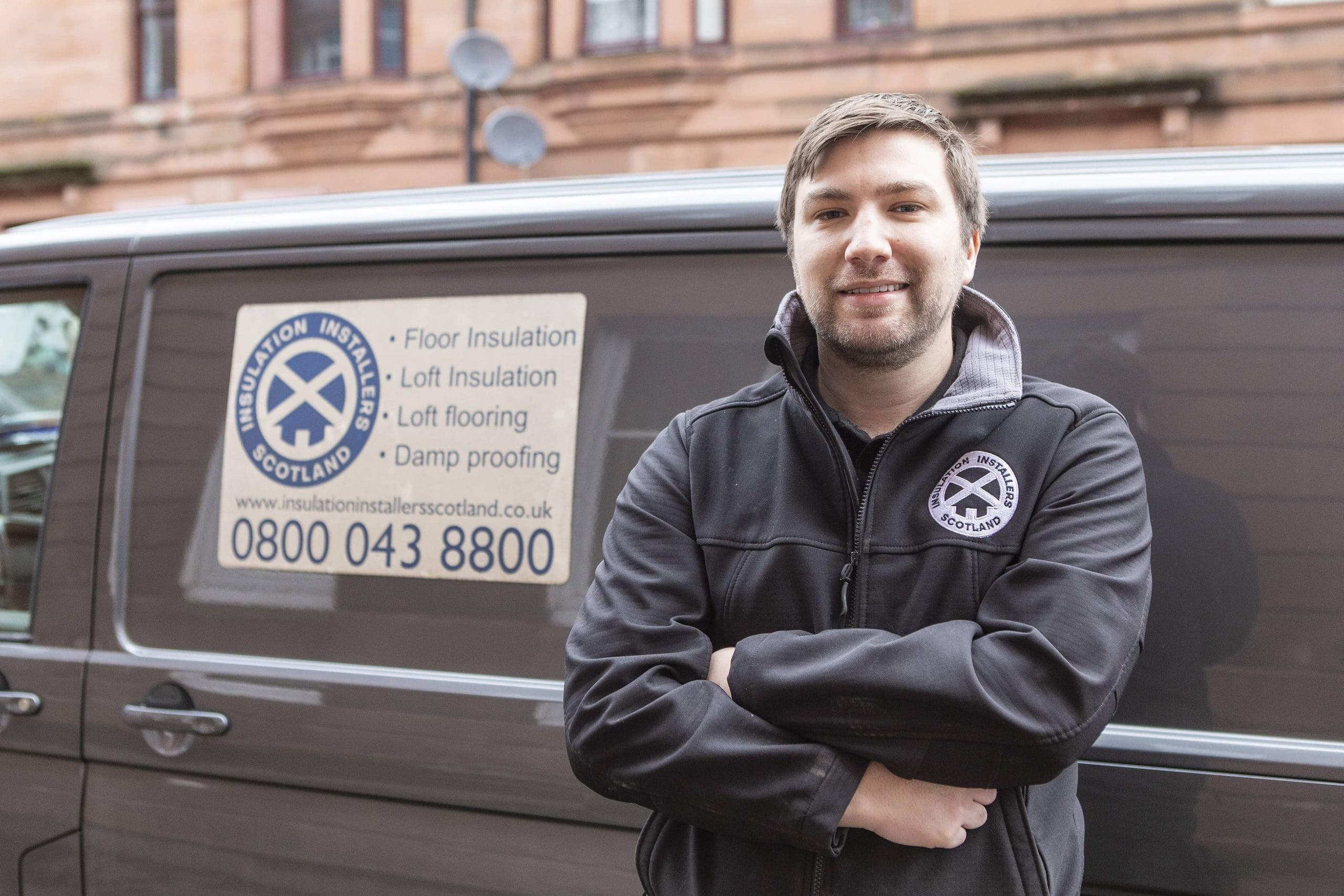 Installer stands in front of van with Insulation Installers Scotland logo